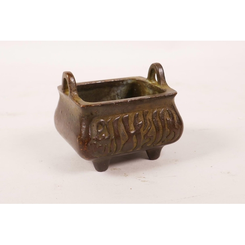 10 - A Chinese bronzed metal censer with two handles and calligraphy decoration, character mark to base, ... 