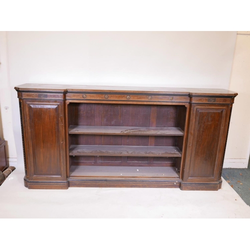 1090 - A Victorian walnut breakfront low bookcase, with ebonised and parcel gilt decoration in the Aestheti... 