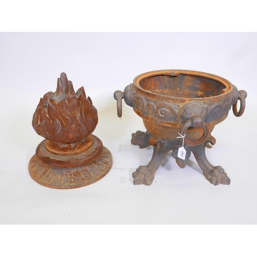 1101 - A C19th cast iron urn with four ring handles, raised on paw feet, the cover cast as a flame, 29