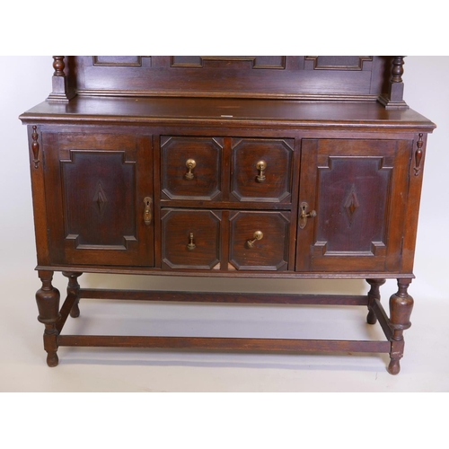 1110 - A Victorian Jacobean style sideboard with carved frieze and panelled upper section over two cupboard... 