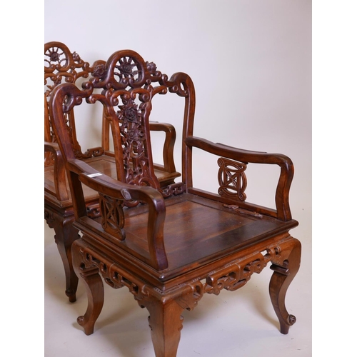 1115 - A set of four Chinese hardwood open armchairs, with carved and pierced backs and friezes, raised on ... 