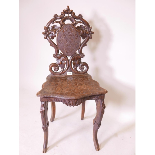 1141 - A C19th Black Forest musical chair with carved and pierced back, raised on cabriole supports