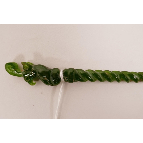 18 - A Chinese green hardstone hair pin with a spiral stem and carved mythical creature to end, 7½