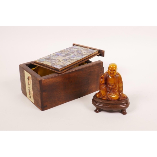 53 - A Chinese soapstone carving of Lohan, on a hardwood stand, with a fitted hardwood box decorated with... 