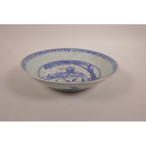 33 - A Chinese blue and white porcelain dish decorated with a figure riding an ox, 8½