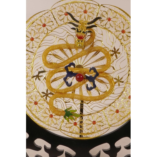 12 - A Chinese gilt wire and enamel plaque with dragon decoration, on a hardwood stand, 10