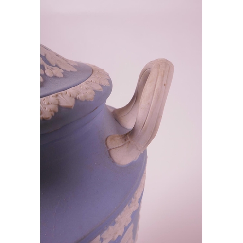 27 - A Wedgwood blue Jasperware two handled urn and cover on stemmed support, inscription 'West End Theat... 