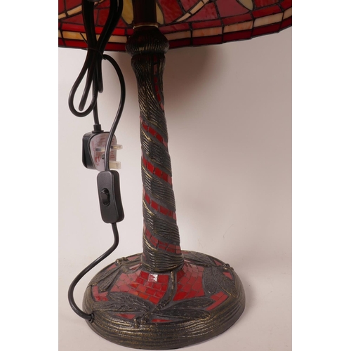 32 - A Tiffany style table lamp with dragonfly decoration on a red ground, 21