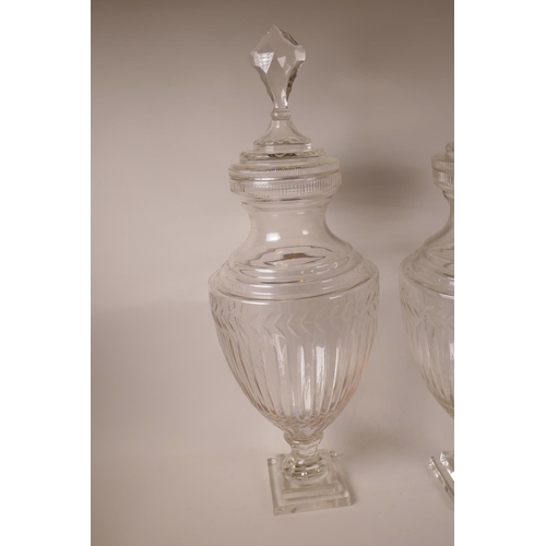 57 - A pair of large glass pedestal urns and covers of baluster form, on a square pedestal base, 28