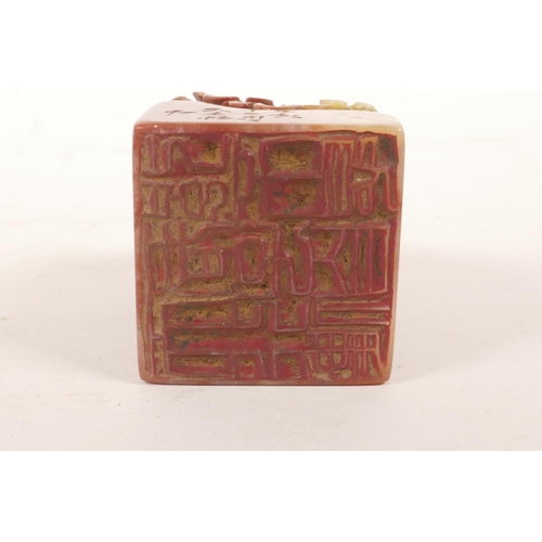 61 - A Chinese chicken blood soapstone seal with carved insect decoration, character inscription to side,... 