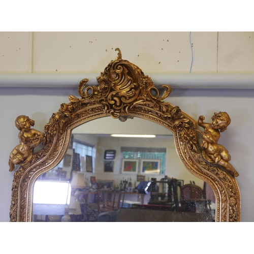 1173 - A French style gilt wood and composition wall mirror, the top flanked by two putti, some losses, 44