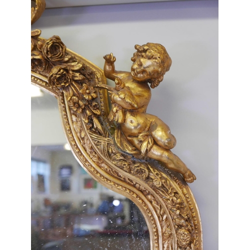 1173 - A French style gilt wood and composition wall mirror, the top flanked by two putti, some losses, 44