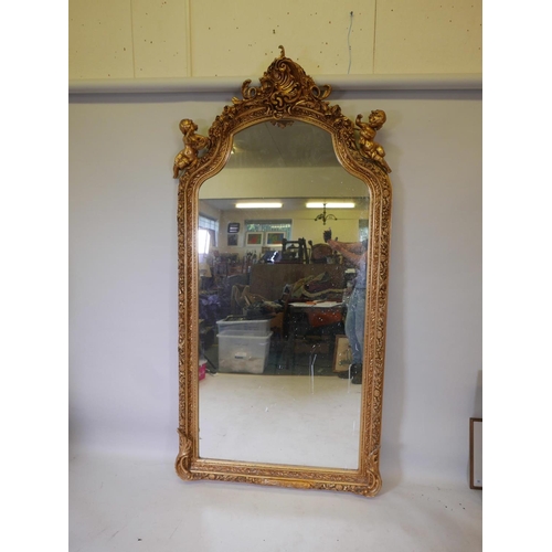 1173 - A French style gilt wood and composition wall mirror, the top flanked by two putti, some losses, 44