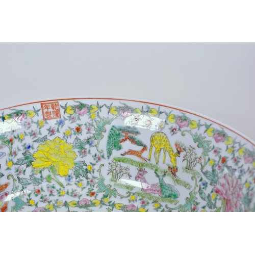 21 - A large Chinese porcelain bowl decorated with deer, mythical beasts and flowers in bright enamels, 1... 