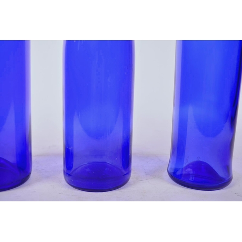 31 - Three 1970s blue glass bottles, largest 13