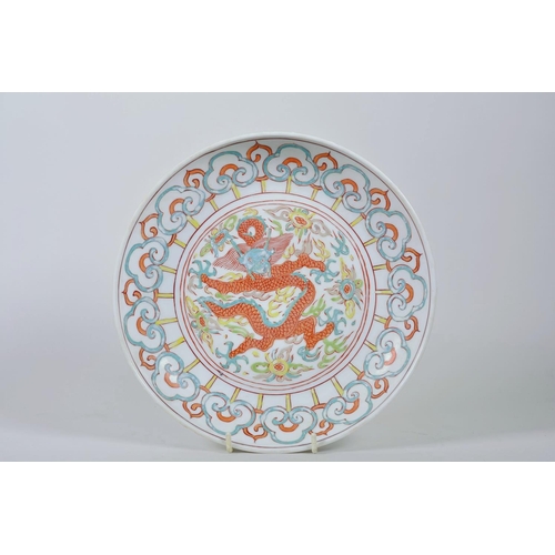 63 - A Chinese polychrome porcelain dish decorated with a dragon and flaming pearl, 6 character mark to b... 