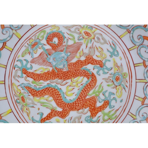 63 - A Chinese polychrome porcelain dish decorated with a dragon and flaming pearl, 6 character mark to b... 