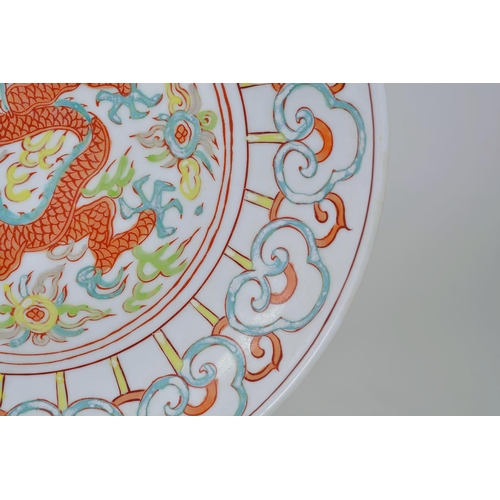 63 - A Chinese polychrome porcelain dish decorated with a dragon and flaming pearl, 6 character mark to b... 