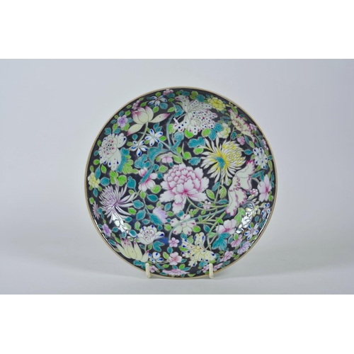 65 - A Chinese famille noire porcelain dish with enamel decoration of Asiatic flowers, 6 character mark t... 