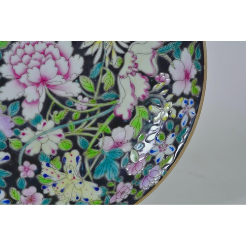 65 - A Chinese famille noire porcelain dish with enamel decoration of Asiatic flowers, 6 character mark t... 