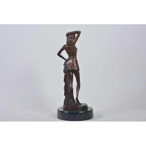 9 - A bronze figure of a girl standing in an artistic pose, marked Nöll, on a round marble stand, 12