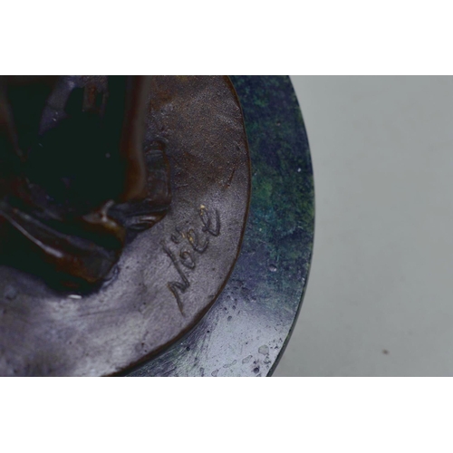 9 - A bronze figure of a girl standing in an artistic pose, marked Nöll, on a round marble stand, 12