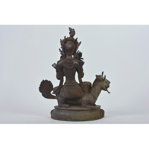 34 - A Chinese patinated bronze figure of Buddha seated on a mythical beast, 10