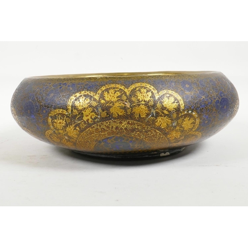 26 - A Kashmiri brass and lacquer bowl with a rolled rim, decorated with gilt floral patterns, signed to ... 