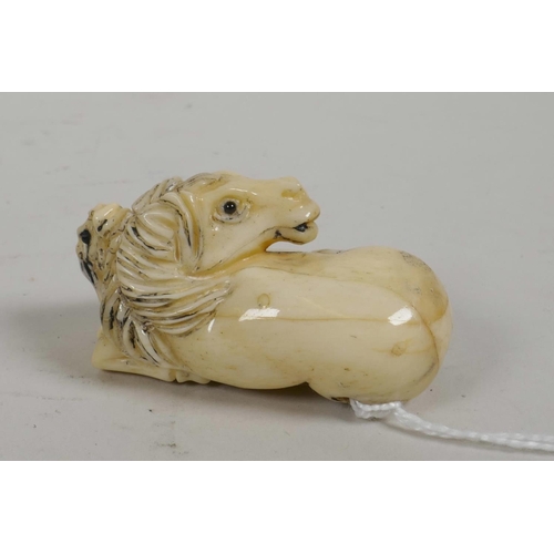 32 - A Japanese bone netsuke carved in the form  of a mare and foal, with glass eyes, signed, 2