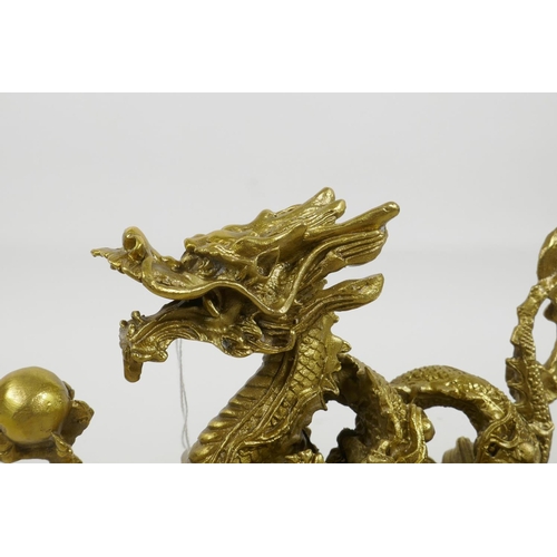 33 - A Chinese gilt metal figure of a dragon clutching the flaming pearl, 8