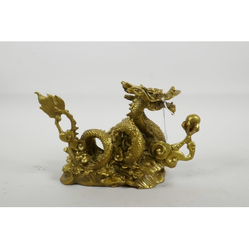 33 - A Chinese gilt metal figure of a dragon clutching the flaming pearl, 8