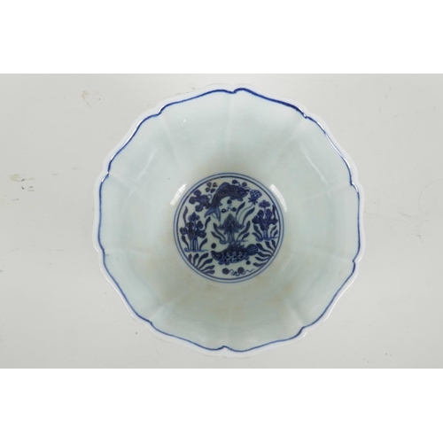 35 - A Chinese blue and white porcelain bowl with a lobed rim, decorated with carp in a lotus pond, six c... 