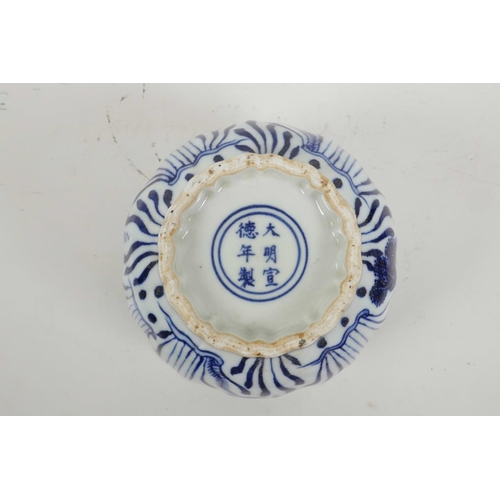 35 - A Chinese blue and white porcelain bowl with a lobed rim, decorated with carp in a lotus pond, six c... 