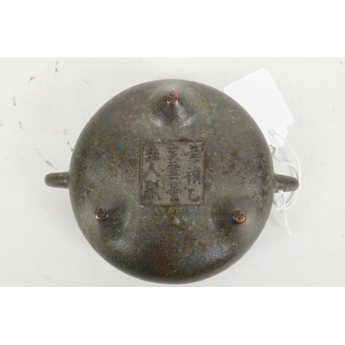 60 - A Chinese bronze two handled censer raised on three supports, with cast character mark to base, 4