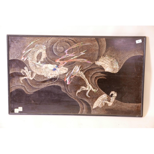 61 - An oriental lacquered panel, with bronzed and inlaid mother of pearl decoration of a dragon in storm... 