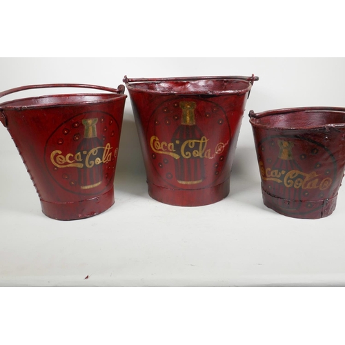 7 - Three graduated metal buckets painted with Coca Cola design, largest 10½