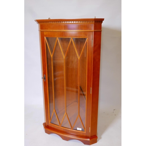 1824 - A bowfronted yew wood hanging corner cabinet with astragal glazed door, 22