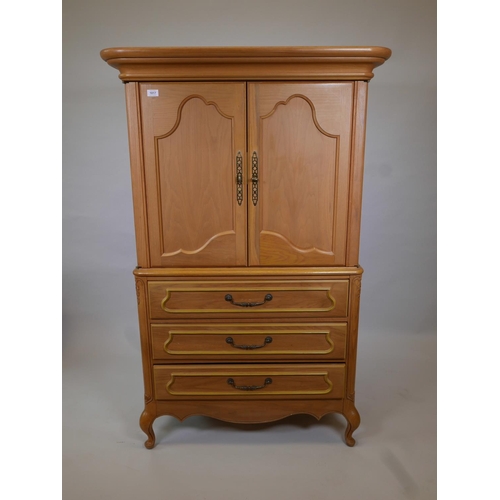 1833 - A one piece oak press cupboard, the cupboard fitted with slide for TV, over three long drawers, rais... 