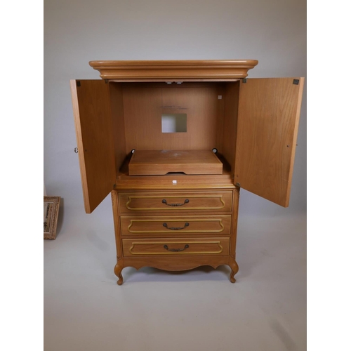 1834 - A one piece oak press cupboard, the cupboard fitted with slide for TV, over three long drawers, rais... 