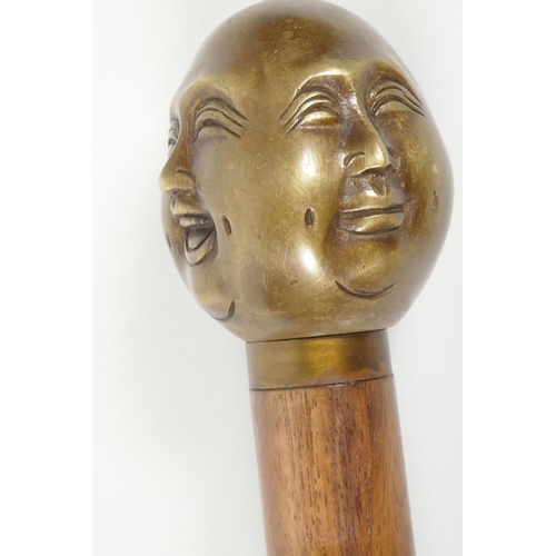 17 - A hardwood walking stick with brass four face Buddha handle, 36