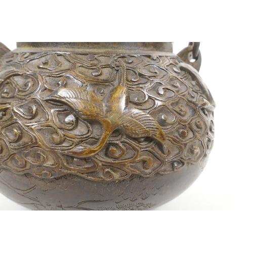 18 - A Chinese bronze teapot with raised decoration of cranes in flight, four character mark to base, 5½