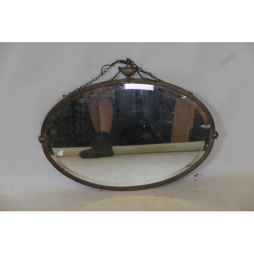 1829 - A brass oval wall mirror with urn decoration to top, 31