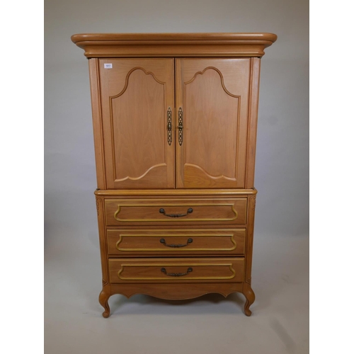 1834 - A one piece oak press cupboard, the cupboard fitted with slide for TV, over three long drawers, rais... 