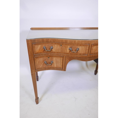 1856 - A C19th inlaid figured mahogany serpentine fronted kneehole desk of four drawers, raised on tapering... 