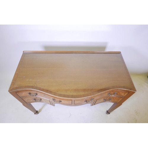 1856 - A C19th inlaid figured mahogany serpentine fronted kneehole desk of four drawers, raised on tapering... 