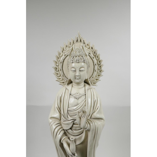 23 - A Chinese blanc de chine Quan Yin on a lotus flower, on an associated hardwood stand, impressed seal... 