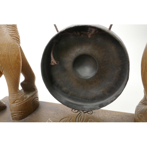 26 - A bronze dinner gong, the wooden stand carved as two elephants with raised trunks, 13