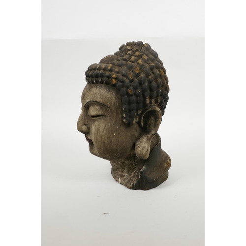 35 - An oriental carved and painted Buddha head, 9½