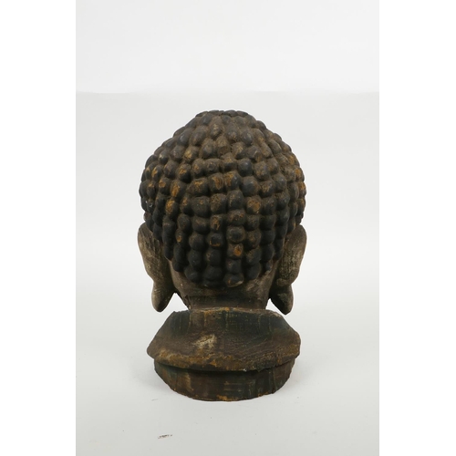 35 - An oriental carved and painted Buddha head, 9½