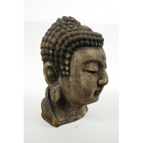 35 - An oriental carved and painted Buddha head, 9½